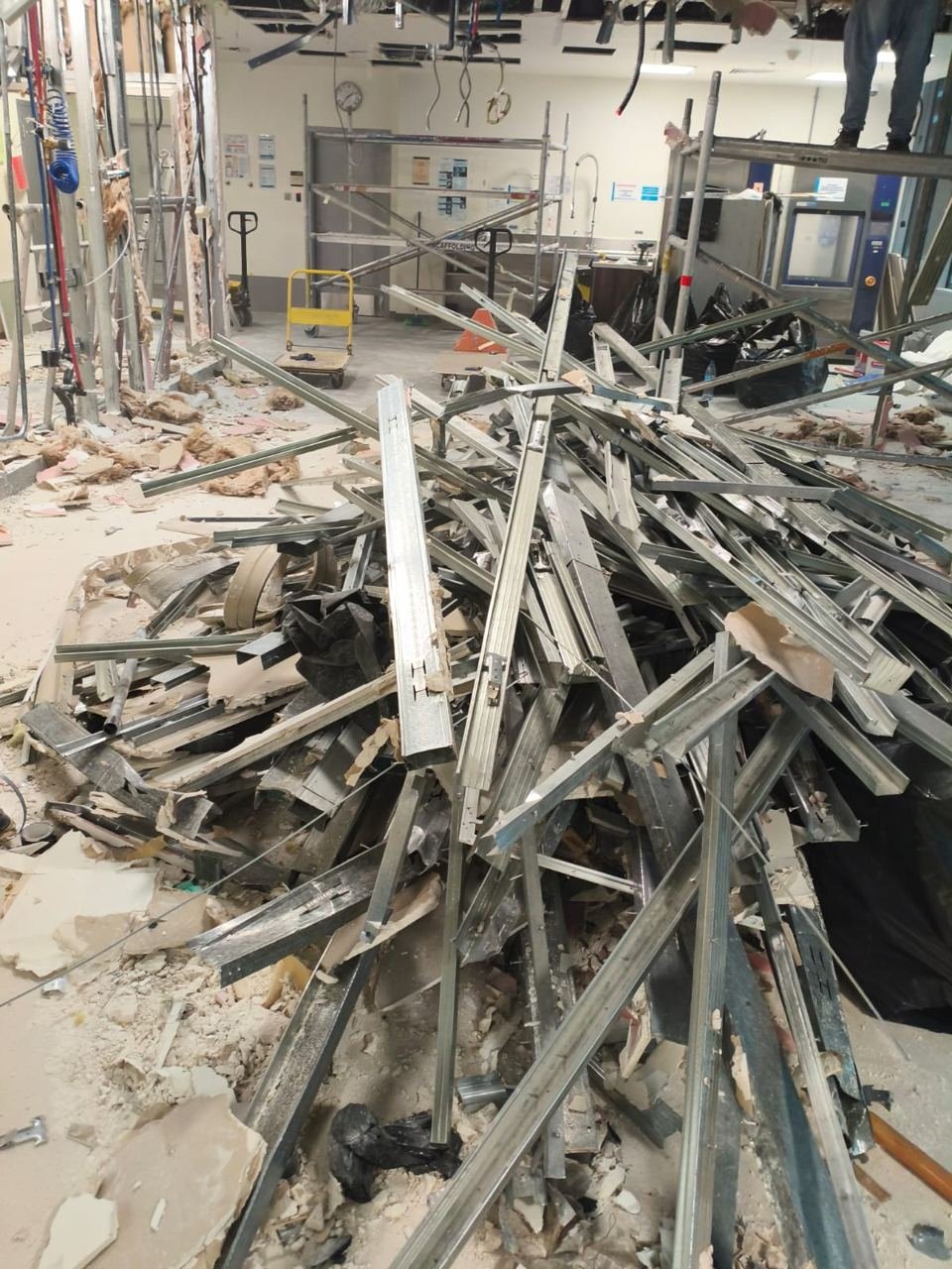 Light-gauge steel studs and channels piled on the floor of an interior demolition site