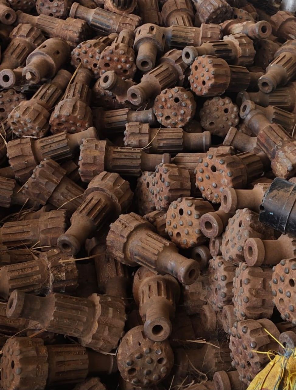 Heap of worn industrial drilling components stacked as heavy metal scrap